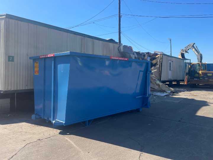 a roll off dumpster rental being dropped at a commercial customers factory in Augusta