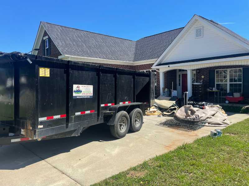 driveway safe dumpster rental being dropped off at a residential location